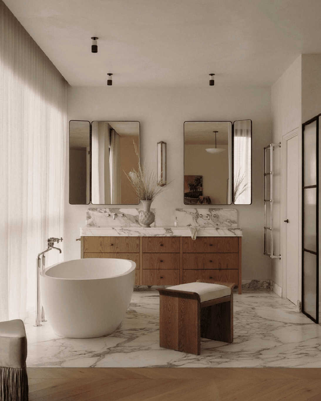 Baño principal con bañera ovalada y vanitory de madera y mármol